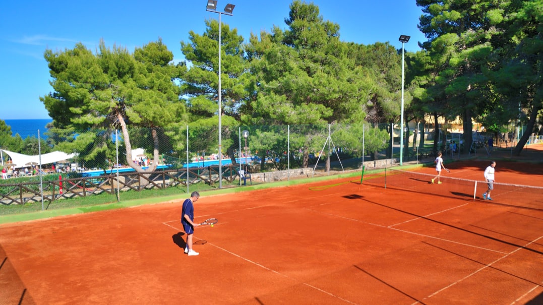 signore che gioca a tennis su campo in terra rossa a Pugnochiuso